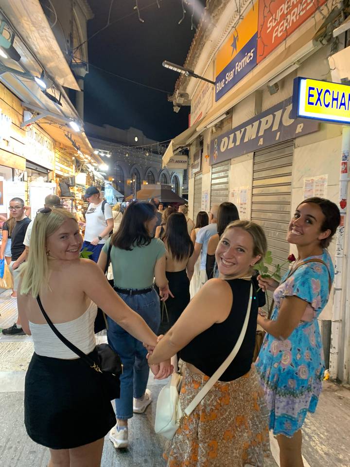 Group of people walking through a busy street market at night.