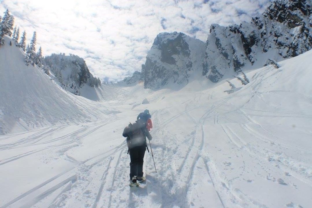 Two people skiing through a snow-covered valley.