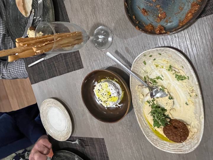 Tafelopstelling met borden met eten en een glas met broodstengels.