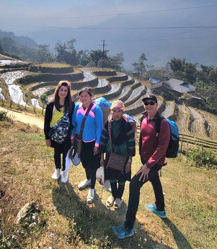 Groep die poseert voor rijstvelden in terrasvormige akkers.