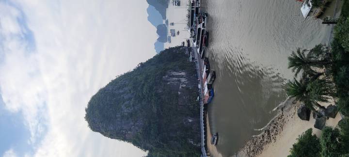 Kalkstenen karstformaties die oprijzen uit een baai met boten.