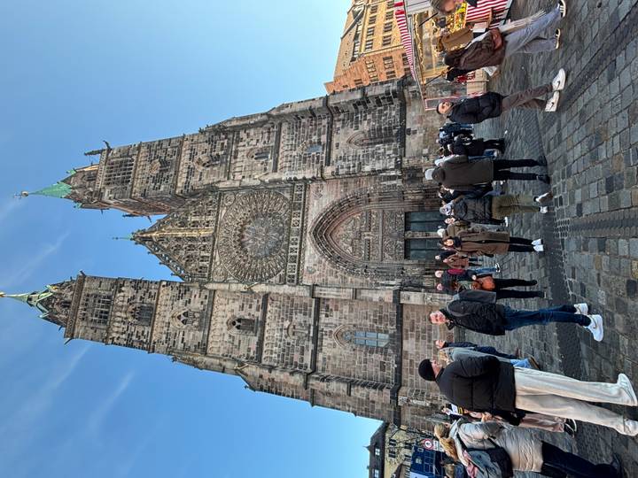 Touristes devant une grande cathédrale historique.