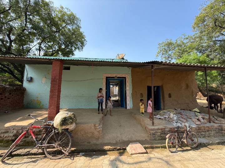 Casa rural sencilla con niños jugando afuera.