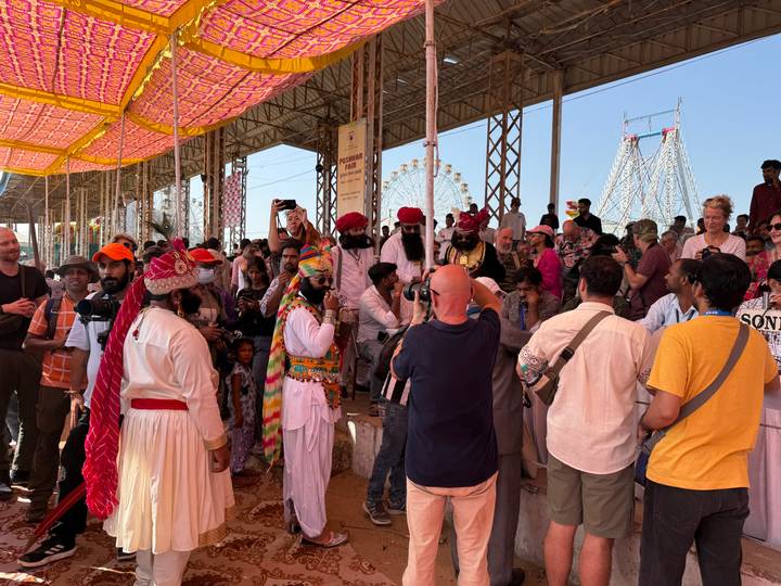 Multitud reunida en un evento cultural con artistas en vestimenta tradicional.