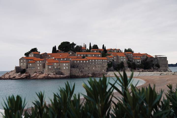 Île avec des bâtiments en pierre et des toits rouges sur la côte adriatique.