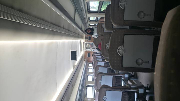 Interior de un vagón de tren con pasajeros.