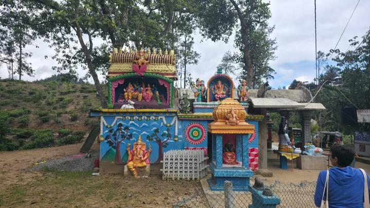 Templo colorido en un entorno de parque con gente.