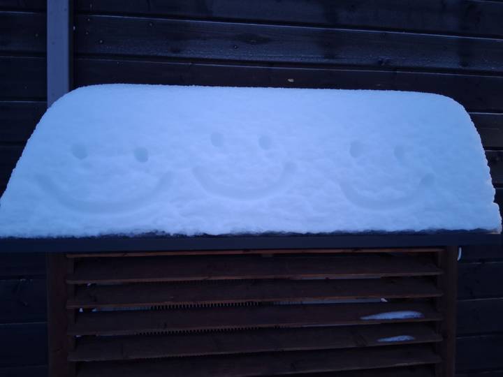 Surface enneigée avec trois visages souriants imprimés.