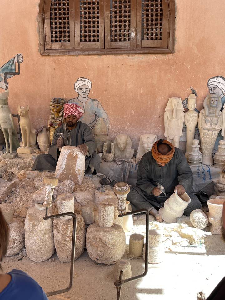 Artisans crafting stone sculptures in a workshop.
