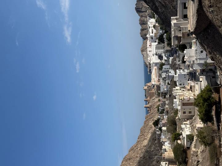 Paisaje urbano con edificios con vista al mar y fortalezas históricas.