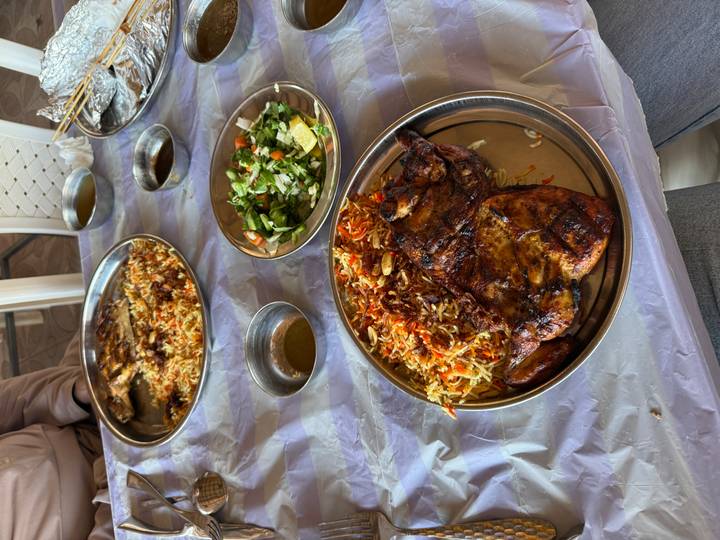 Platos con carnes asadas y arroz sobre una mesa.