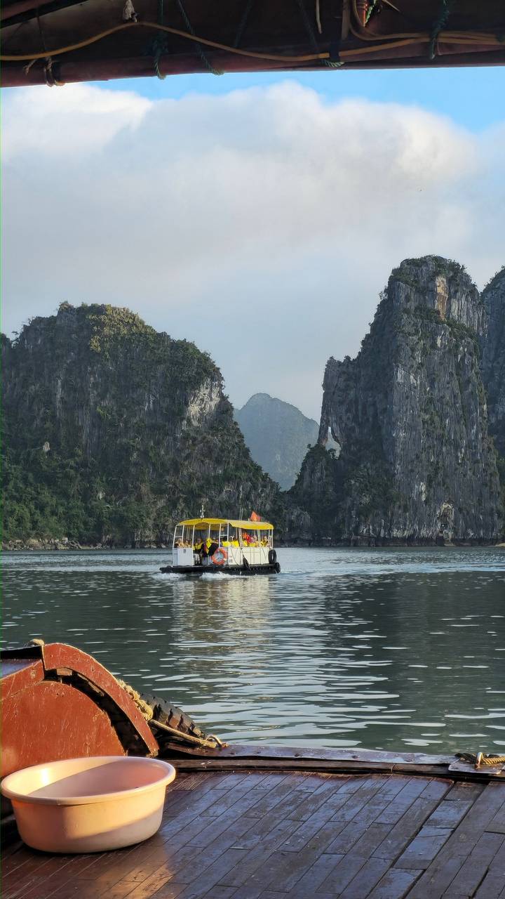 Tourists on a boat with rocky cliffs in the background.