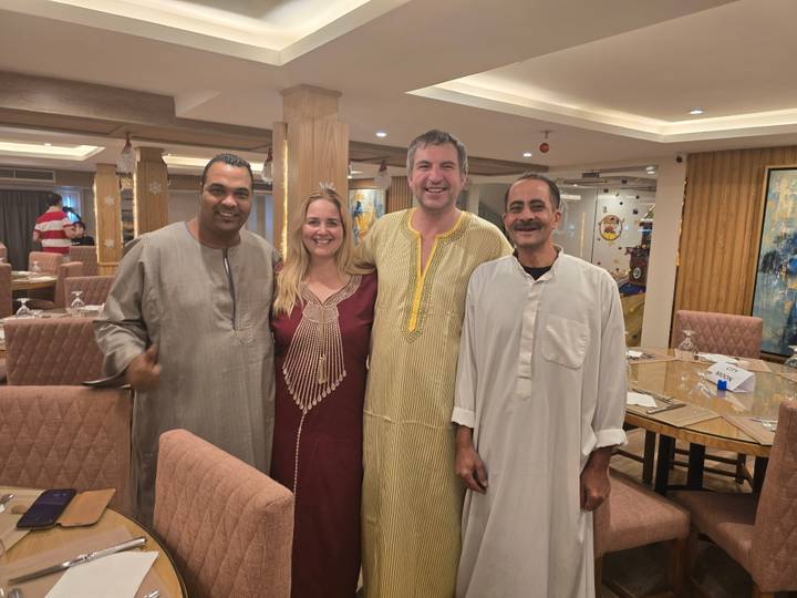 Groupe vêtu de vêtements traditionnels posant dans une salle à manger.