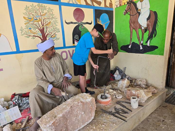 Enfant assistant des artisans dans un atelier de production traditionnelle.