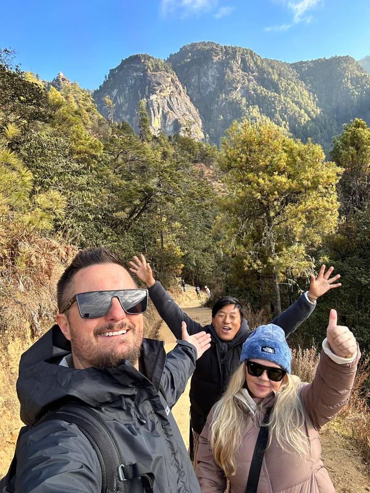 Personas posando en una zona boscosa, disfrutando de una actividad al aire libre.
