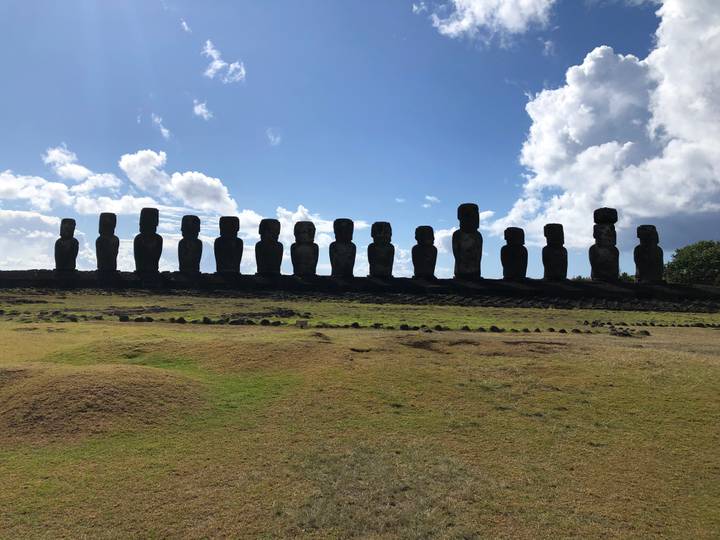 Silhouette of moai statues against the sky.