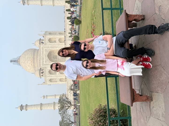 Familia posando frente al Taj Mahal, un famoso monumento arquitectónico.