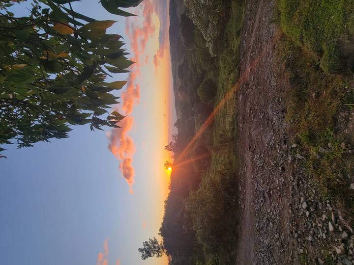 Sunset over a serene landscape with trees and hills in Costa Rica.