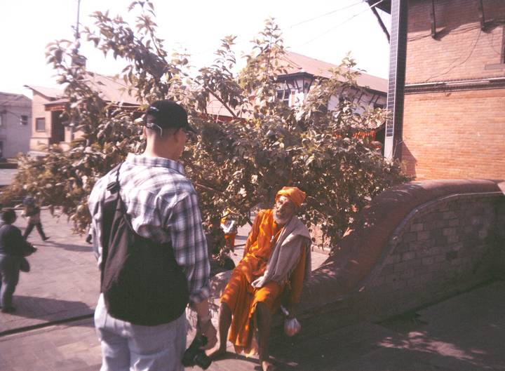 Hombre interactuando con un anciano en un entorno tradicional.
