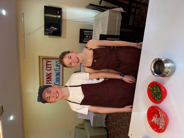 Dos jóvenes posando en un ambiente de clase de cocina.