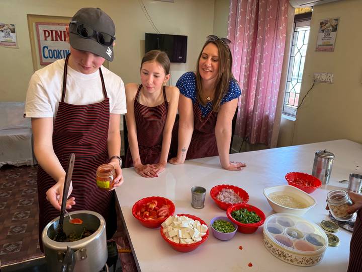 Familia participando en una clase de cocina con varios ingredientes.