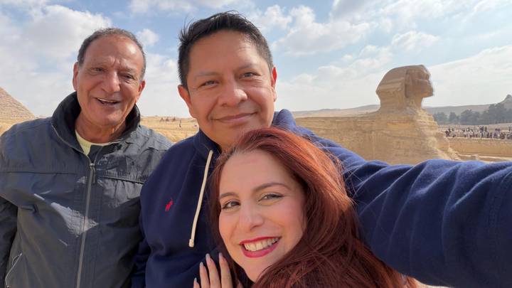 Trois personnes prenant un selfie avec le Sphinx et la pyramide en arrière-plan.