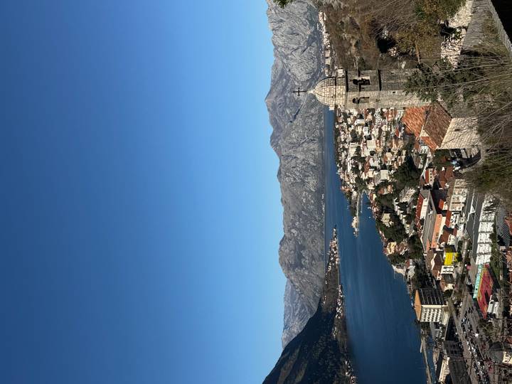 Vista sobre un pueblo con montañas y una bahía.