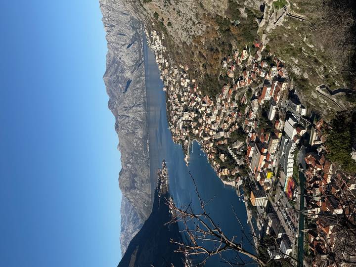 Paisaje urbano a lo largo de una bahía rodeada de montañas.