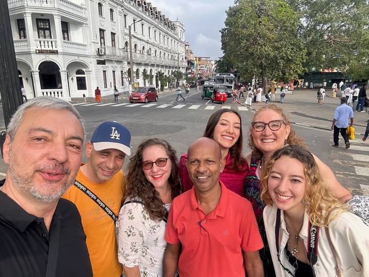 Groupe de touristes dans une rue devant une architecture coloniale.