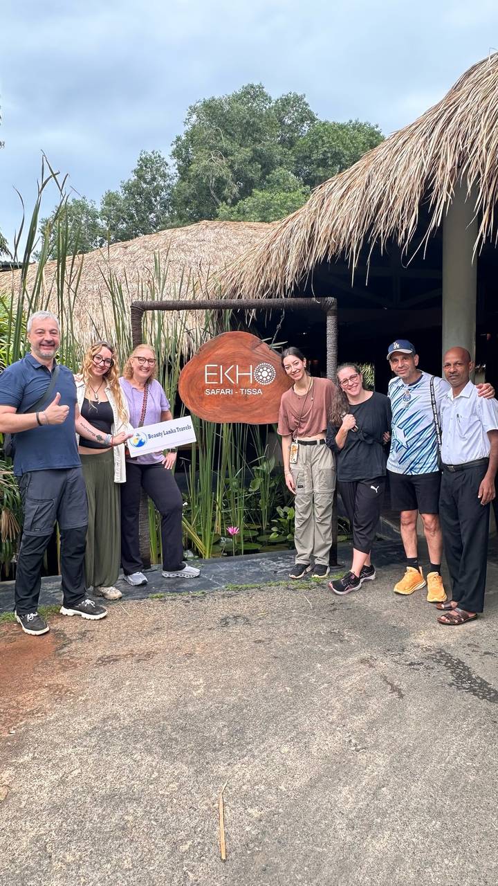 Groupe posant avec un panneau de visite dans un lodge de safari.