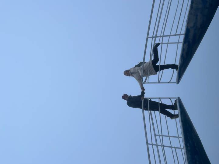 Dos personas posando en un puente rodeado de niebla.