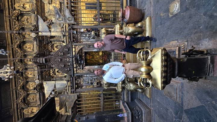 Deux personnes sur un site historique, debout entre des lions de pierre.