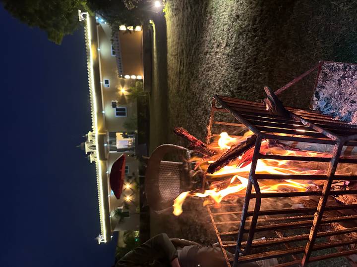 Feuerstelle im Freien mit einem Haus im Hintergrund bei Nacht.