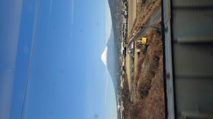 Mount Fuji visible from moving train with clear skies.