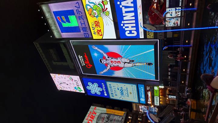 Famous Glico sign in vibrant city area at night.
