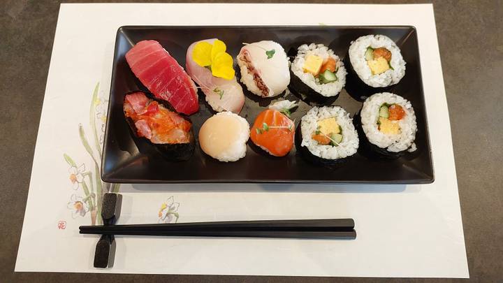 Plateau de sushis assortis sur une table décorative.