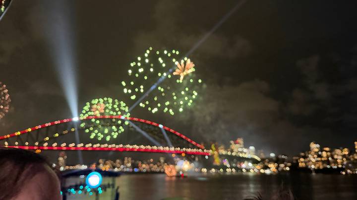 Espectáculo de fuegos artificiales sobre un puente de la ciudad por la noche.