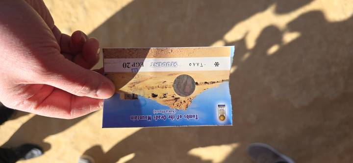 Person holding a ticket for the Tombs of the Dead Mountain.