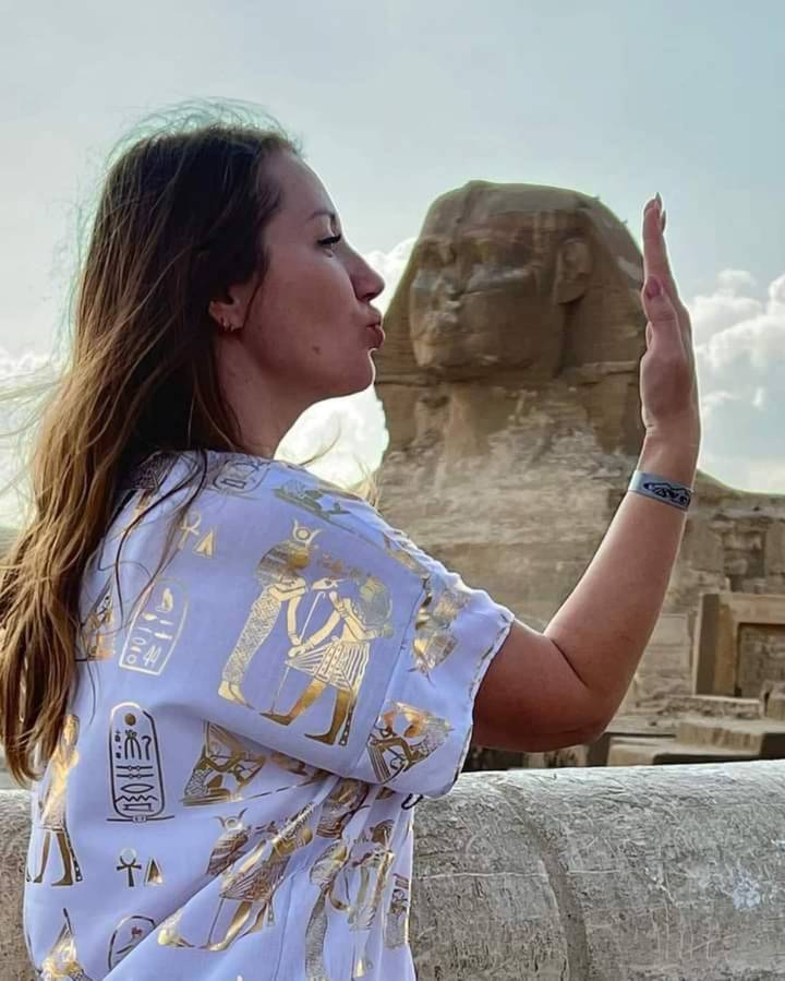 Mujer posando con la Esfinge de fondo en Giza.