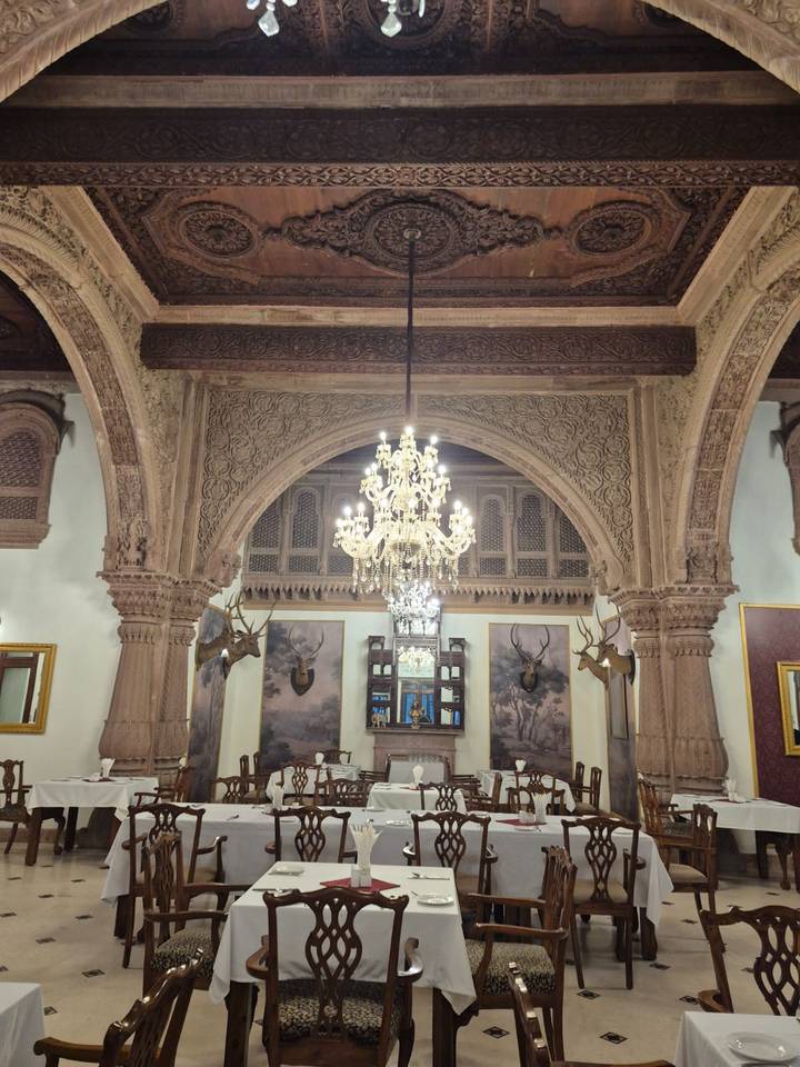 Interior con una lámpara de araña y techo y paredes ornamentalmente decorados.