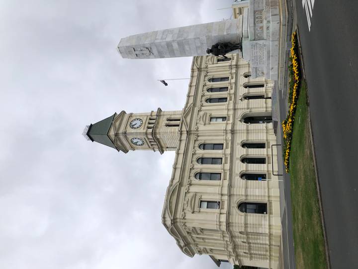 Edificio de torre del reloj de un ayuntamiento con una bandera.
