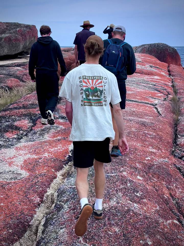 Man walking on a rocky path with others.