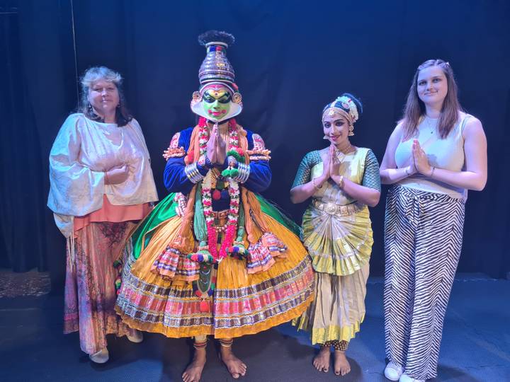 Danseurs en costumes colorés sur scène.