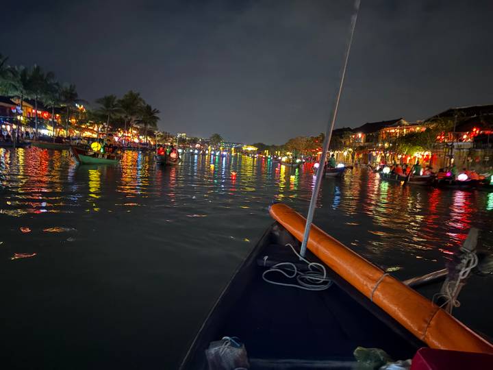 Night view of a river with colorful lights reflecting on the water.