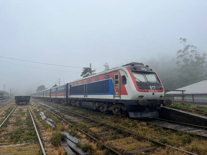 A train on railway tracks in a foggy environment.