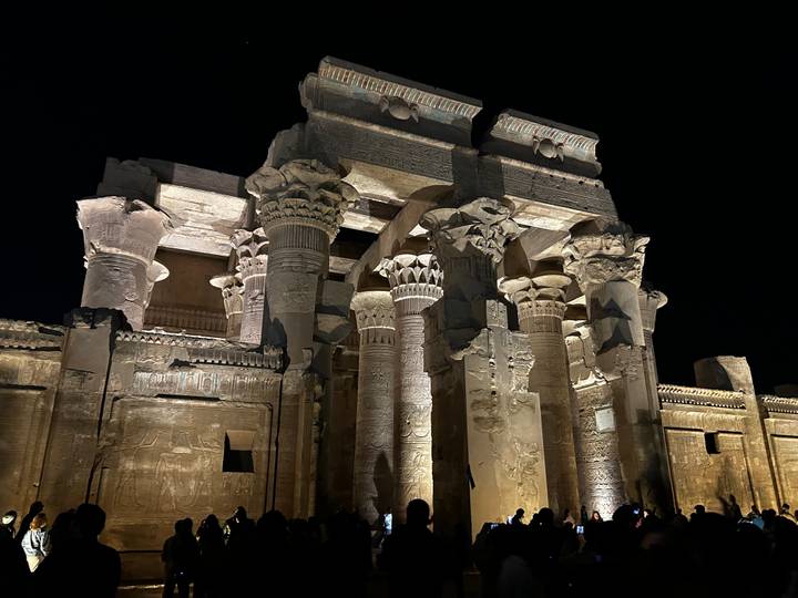 Colonnes antiques éclairées la nuit avec des hiéroglyphes.