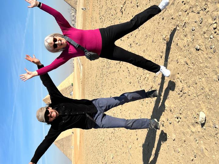 Deux personnes sautant joyeusement devant les Pyramides