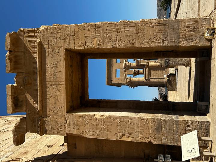 Portail de pierre avec hiéroglyphes menant à d'autres structures