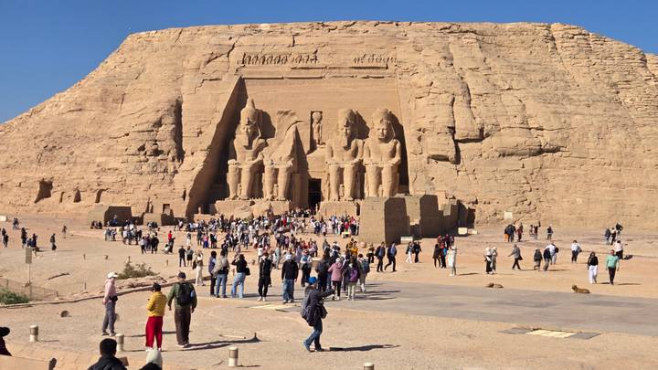 Tourists visiting the Abu Simbel temples against a clear sky.
