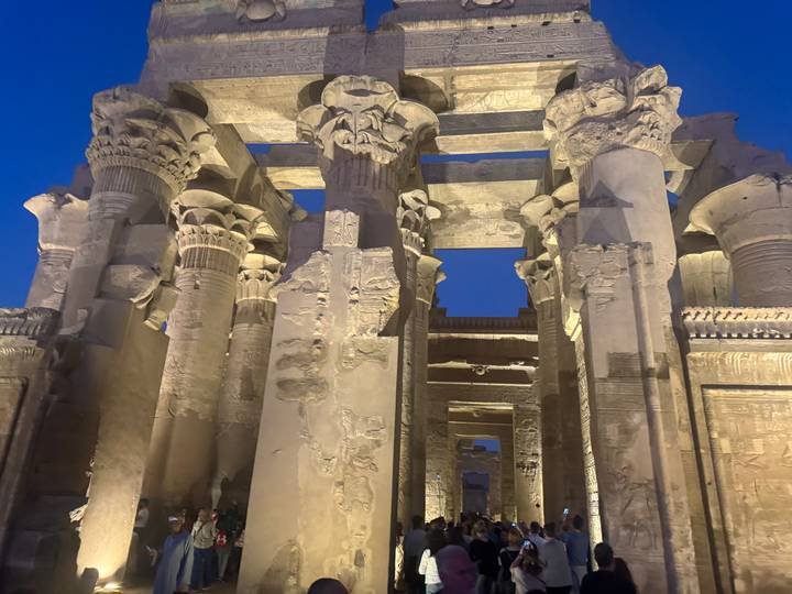 Illuminated ancient columns at the Kom Ombo Temple at night.